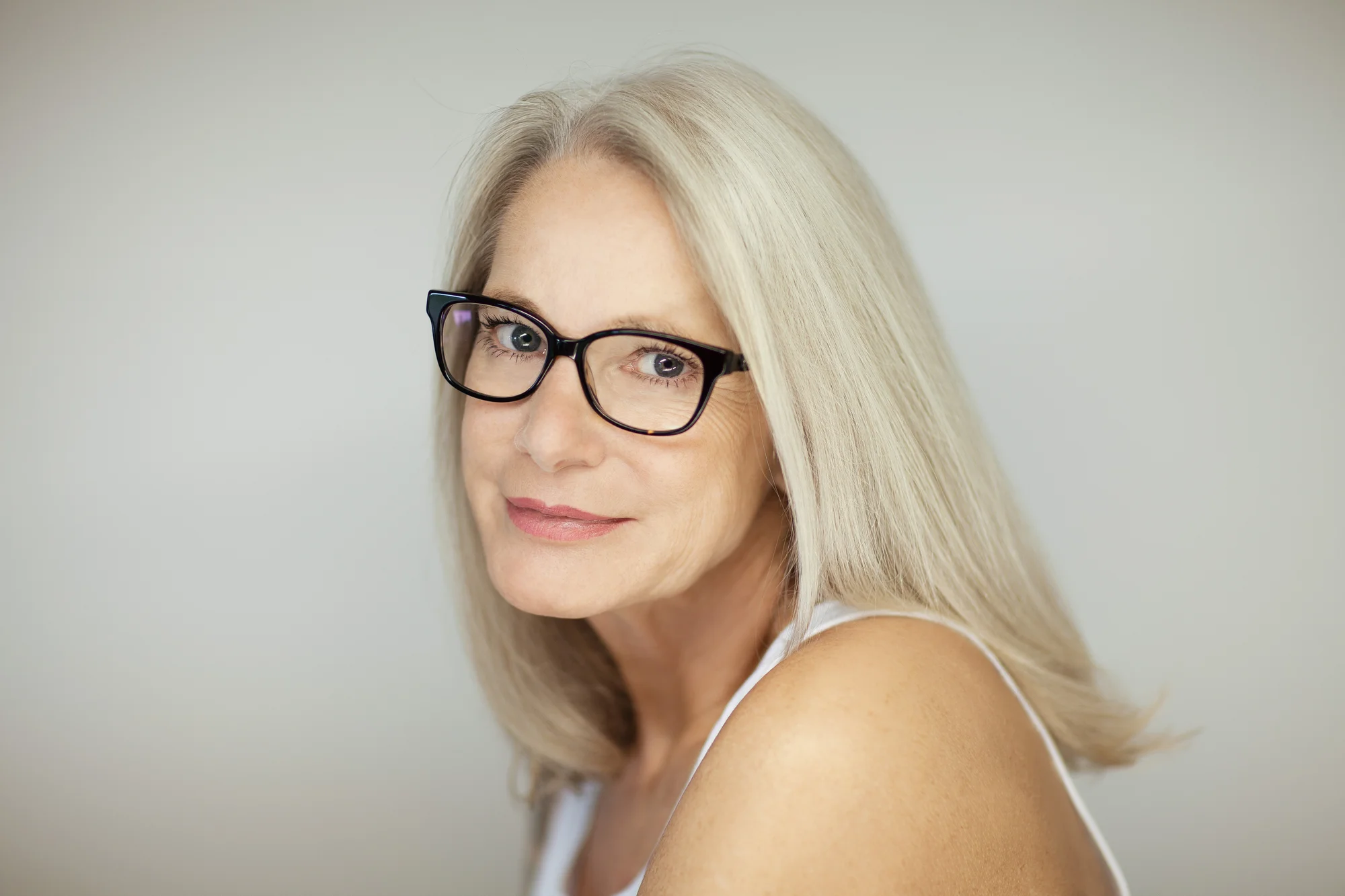 Workplace menopause - A close up of a blonde heaired woman wearing glasses, middle-aged