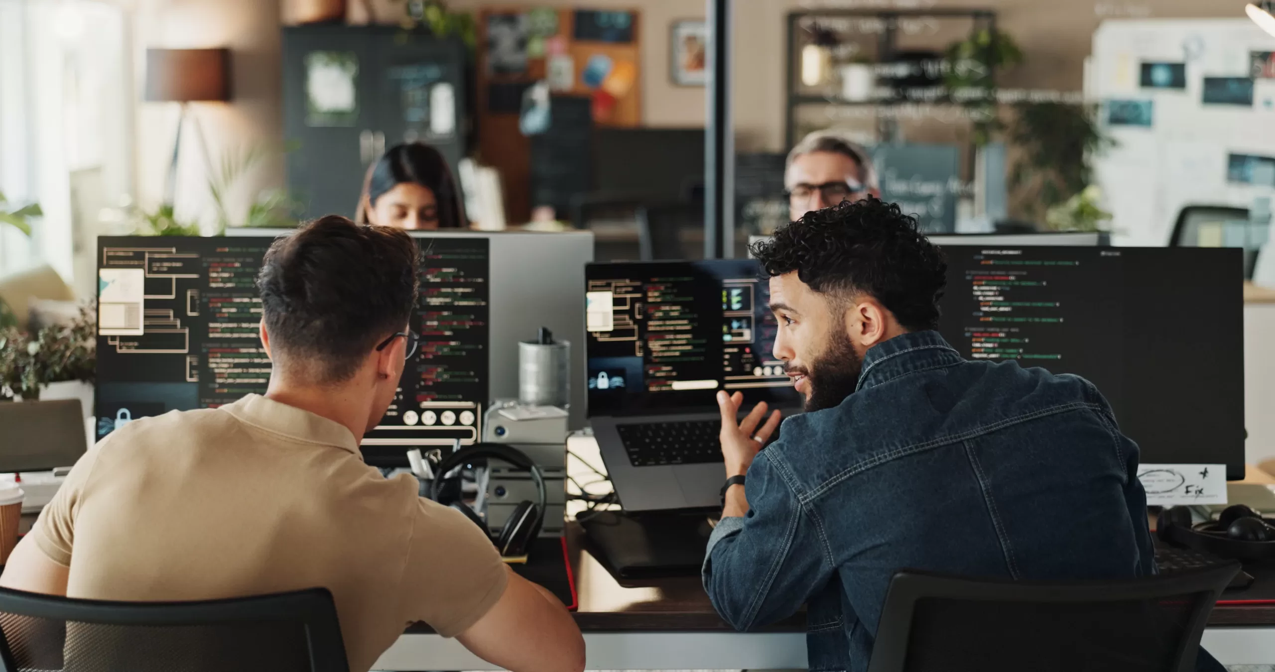OH Software and Data Solutions - Two developers sitting in front of a bank of computer screens
