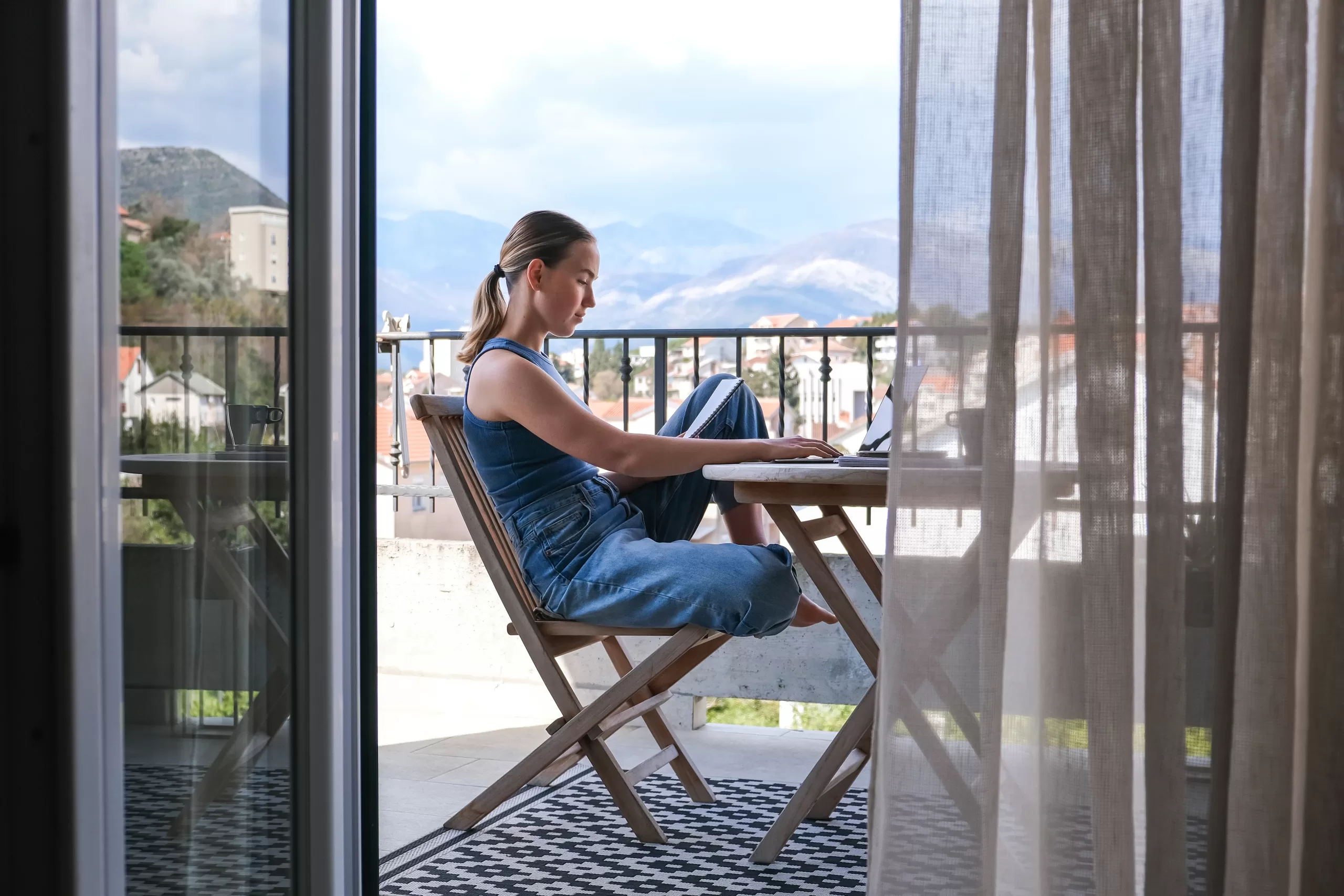 Promoting Work-Life Balance - Female on balcony during daylight hours with laptop